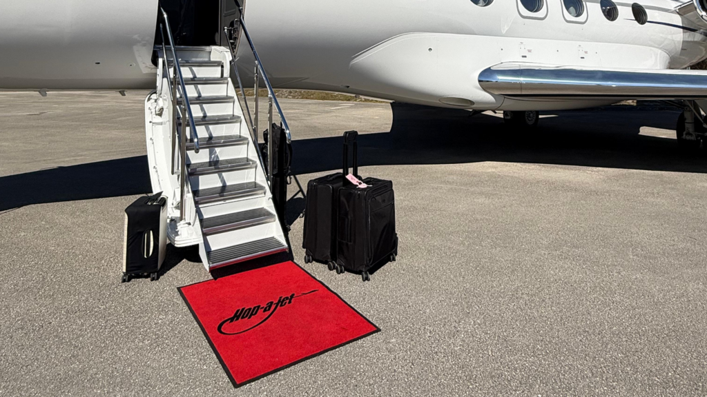 Hop-A-Jet private jet boarding stairs with luggage on the tarmac, illustrating how much does it cost to charter a private jet for a personalized luxury flight experience.